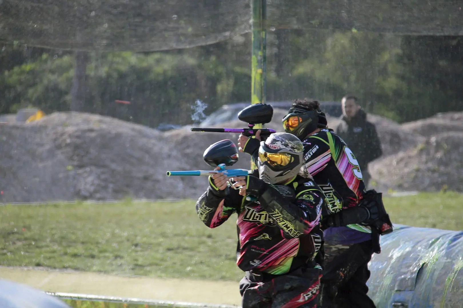 deux hommes qui tirent avec leurs armes paintball