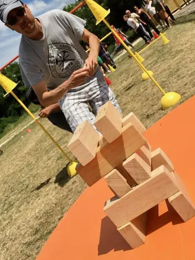 Participant réalisant un jeu d’équilibre avec des blocs de bois lors d’une activité en plein air