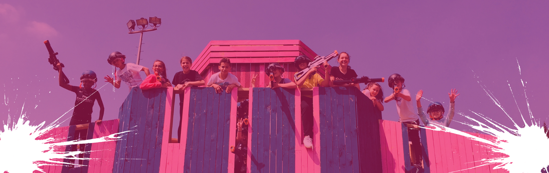 enfants sur une structure paintball rose et bleue en bois
